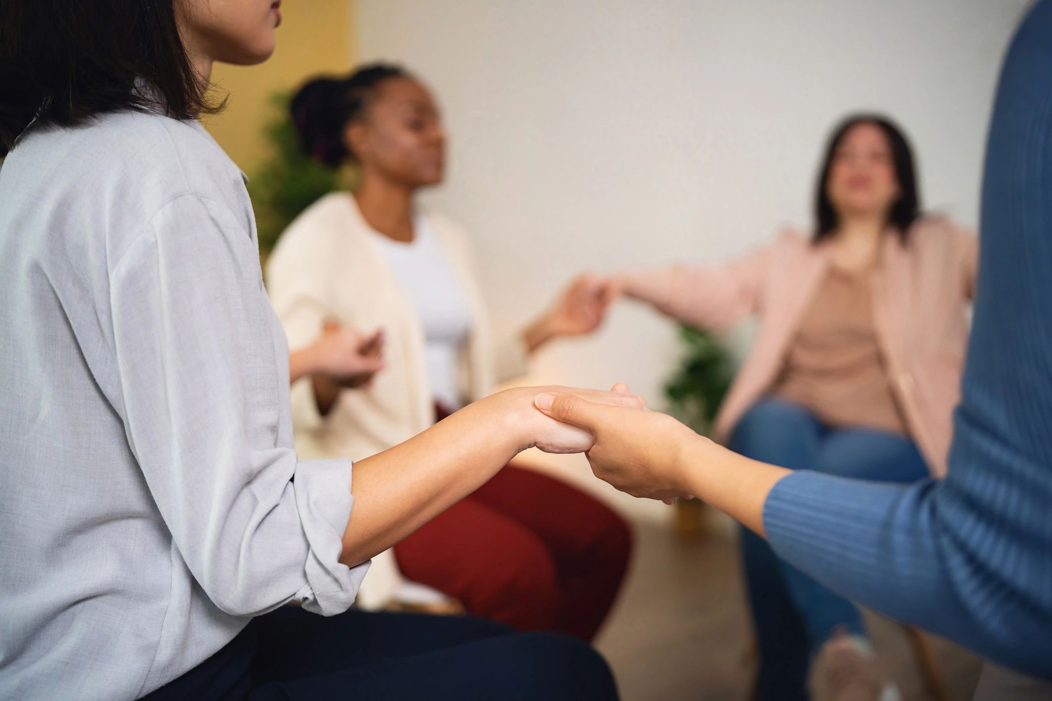 Group holding hands in a circle during support session