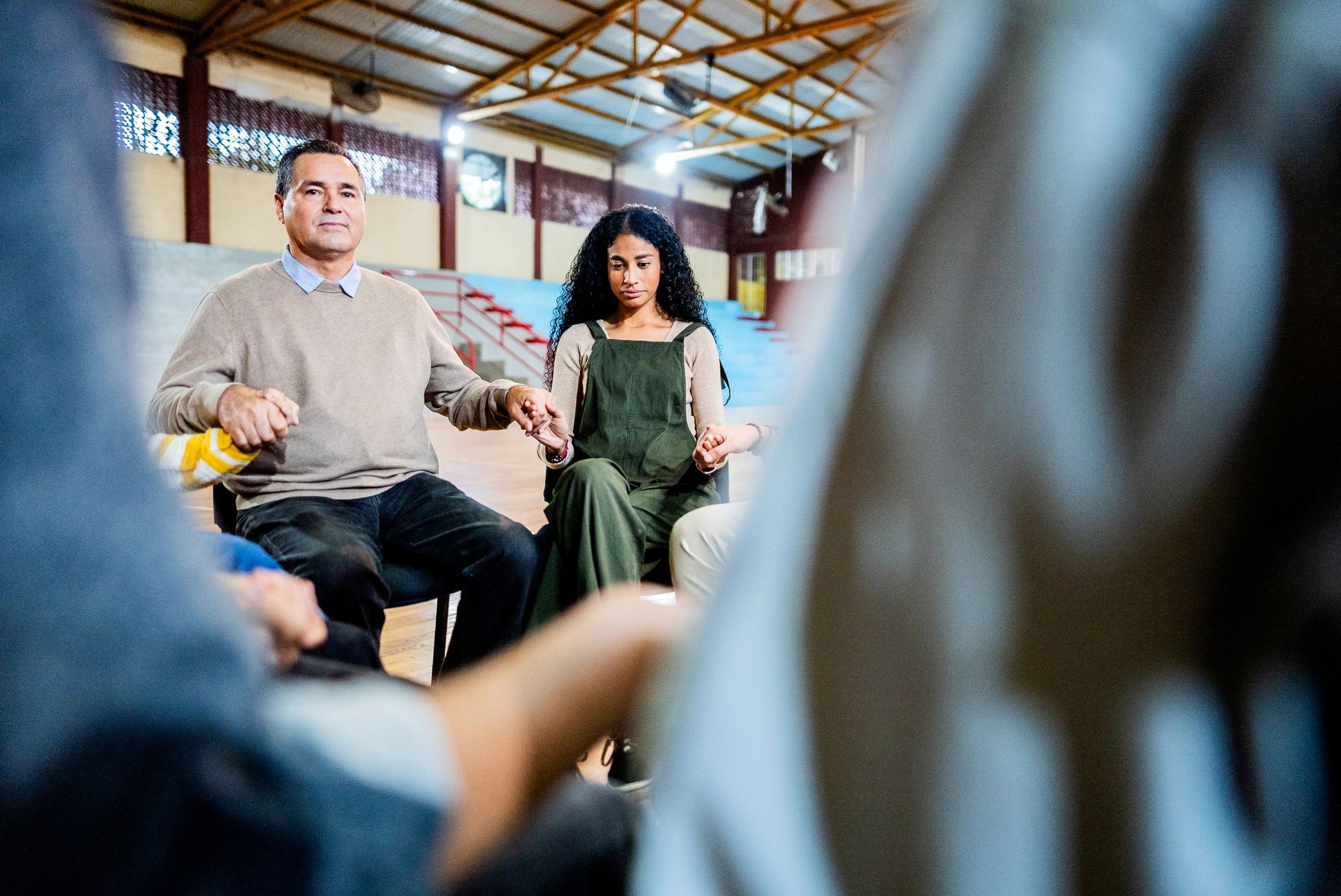 Therapist in group setting with hands together