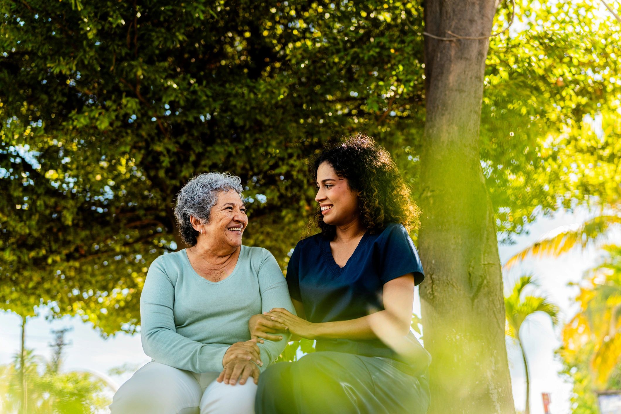 Caregiver and older woman talking outdoors