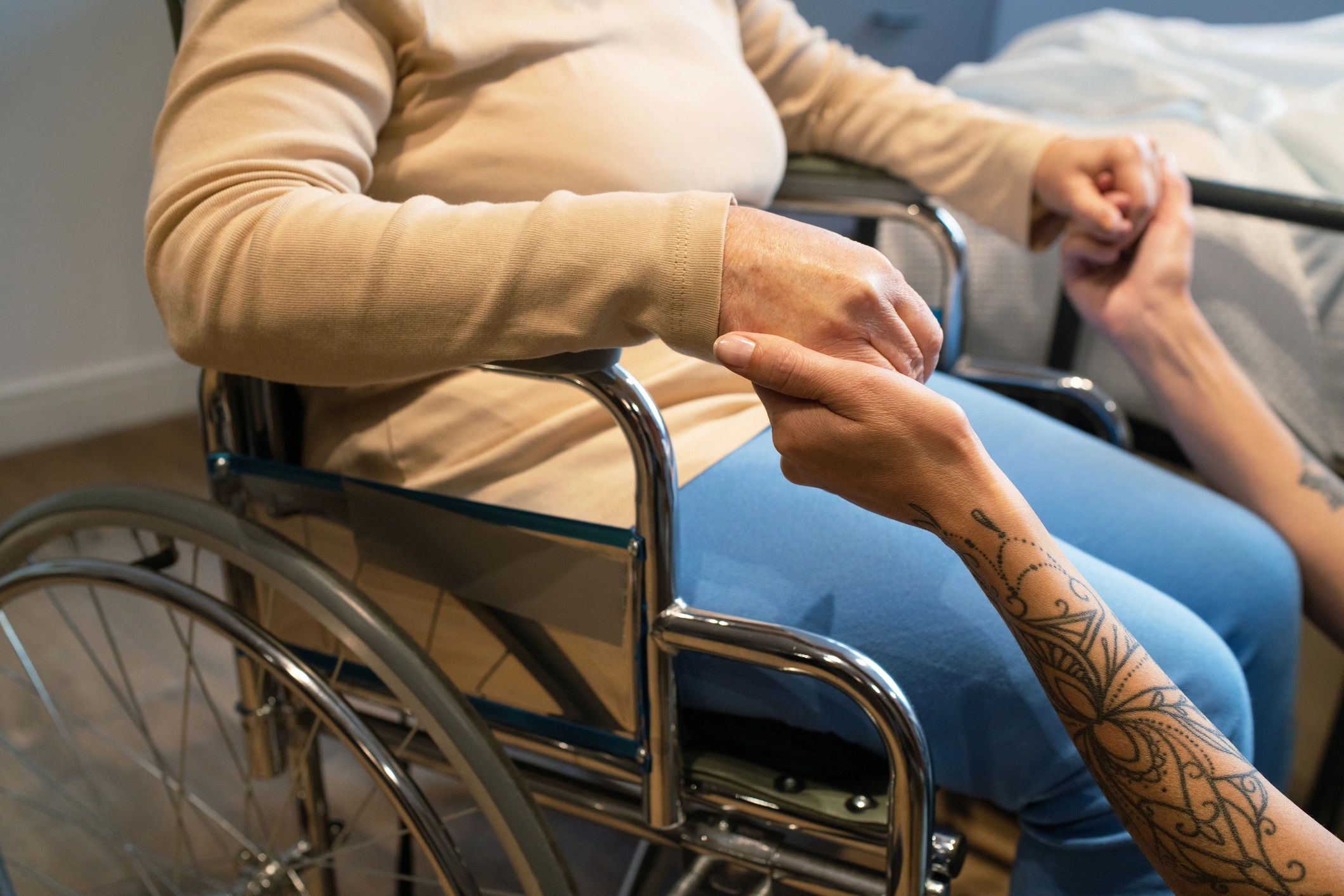 Senior resident holding hands with nursing home caregiver