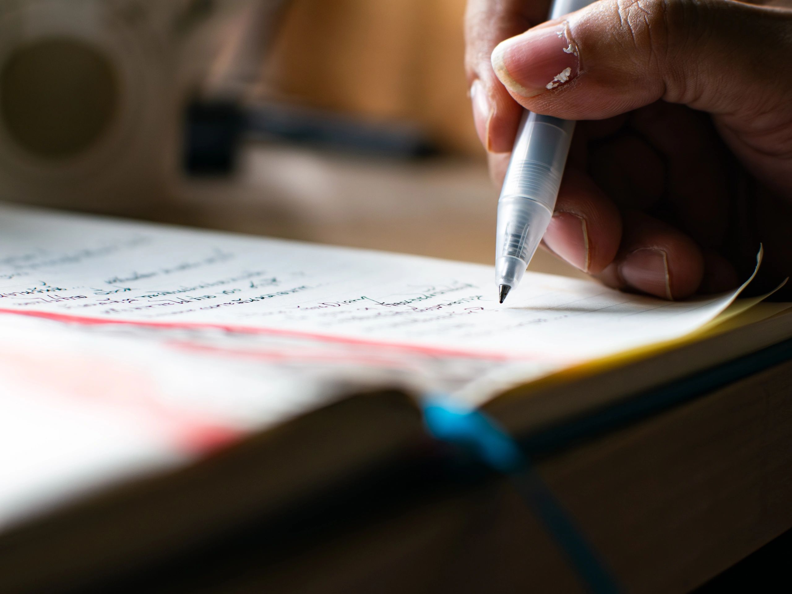 Close-up of hand writing notes in a notebook